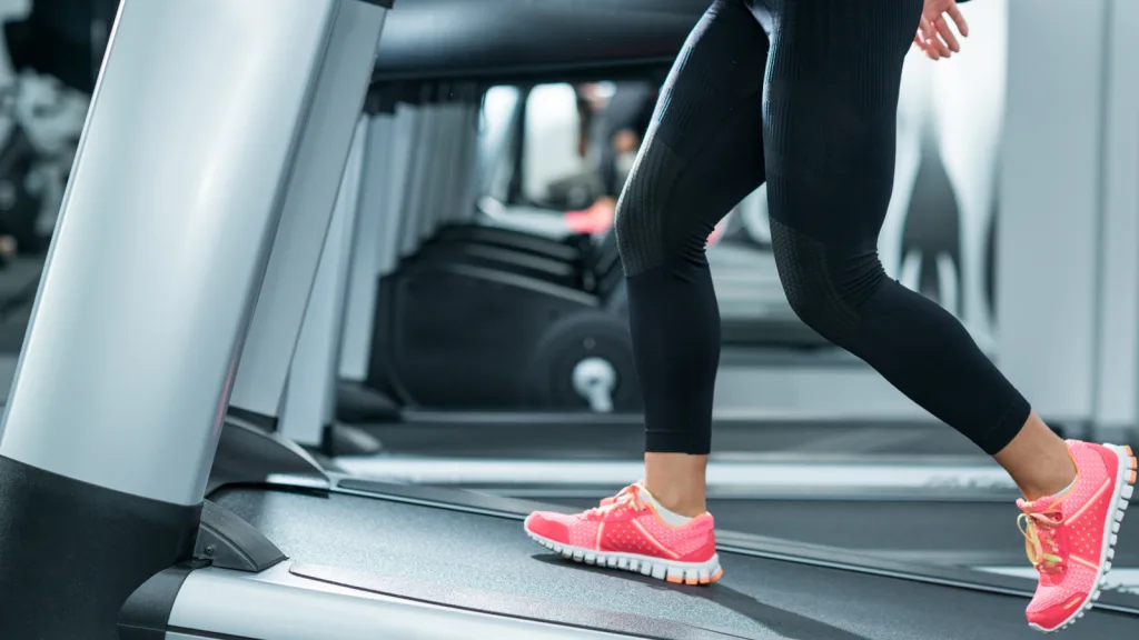 Photo of the bottom half of woman walking on the treadmill at an incline. Her sneakers are pink and lime green, with black athletic pants on. New pet-friendly apartment homes for rent with private fenced backyards in Arizona, Texas, Florida, and North Carolina with pool, pickleball, dog park, gym, clubhouse and gated community. *No breed or weight restrictions. Yardly